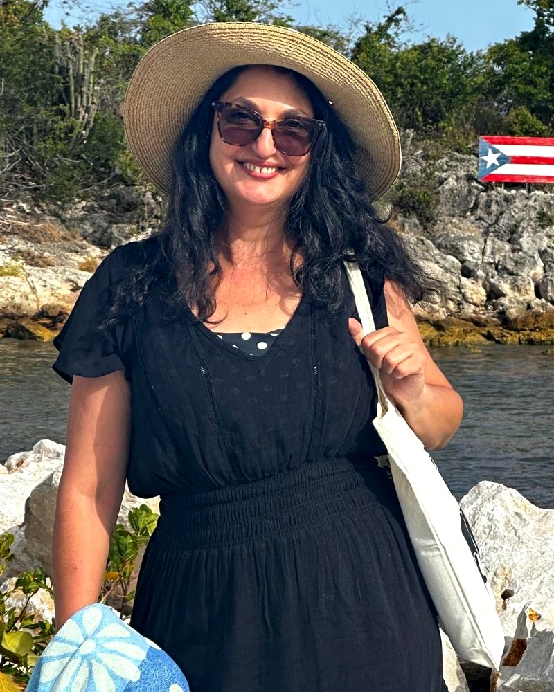 Rima Brusi in Puerto Rico, a Puerto Rican flag painted on the rocks behind her